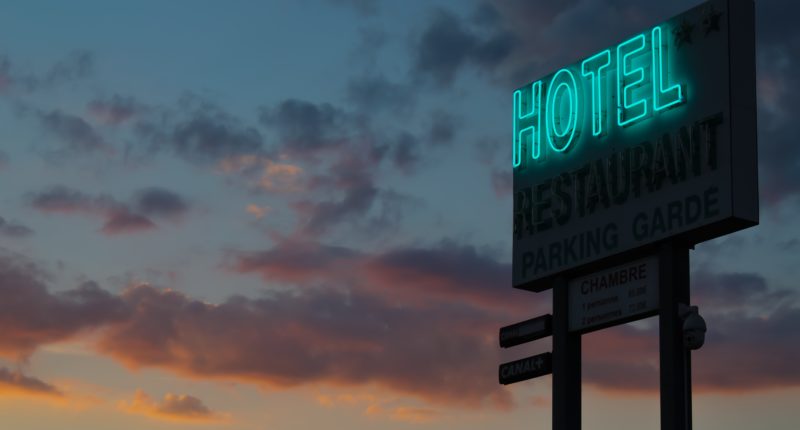 turned-on green hotel LED light signage ahead
