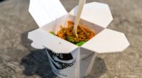 white and black paper cup with brown pasta